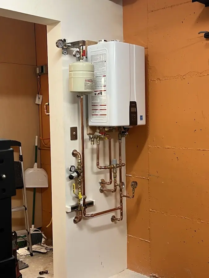 Plumbing technician inspecting water heater connections in Brentwood